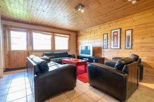 a living room with two leather couches and a television at Himospeili in Jämsä
