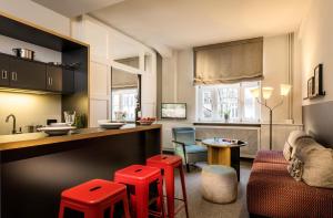 eine Küche und ein Wohnzimmer mit roten Hockern in der Unterkunft Apartment040 in Hamburg