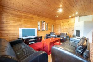 a living room with leather furniture and a flat screen tv at Himospeili in Jämsä