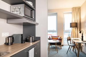 a kitchen and dining room with a table and chairs at sylc. Apartmenthotel – Serviced Apartments in Hamburg