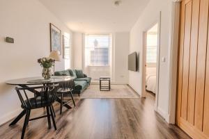 a living room with a table and a couch at Barnet House Serviced Apartments in Dunfermline