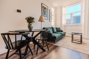 a living room with a table and a couch at Barnet House Serviced Apartments in Dunfermline +63 photos