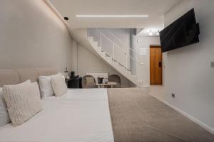 a bedroom with a large bed with a tv on the wall at SPA apartamentai Palanga in Palanga