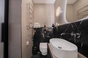 a bathroom with a white sink and a toilet at SPA apartamentai Palanga in Palanga