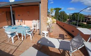 a patio with a table and chairs on a balcony at Riserva Verde in Castel Porziano