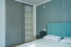 a bedroom with a bed with a blue headboard and a chair at Studio Vata in Vaţa de Jos +16 photos