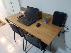 a laptop computer sitting on top of a wooden desk at Studio 215 Campinas SP in Campinas