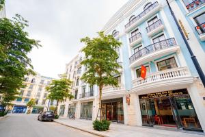 a building on a street with a tree in front of it at Hotel Hải Âu in Sầm Sơn