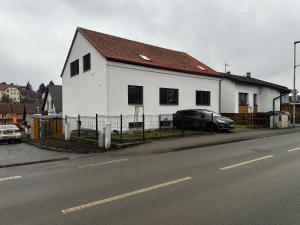 a white house with a car parked next to a street at Byt v podzámčí in Litomyšl