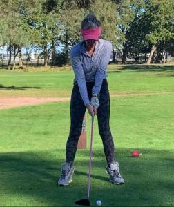 a woman is playing golf on a golf course at Commuters Haven perfect for conferences airport and offices near airport in Cove