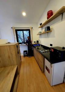 a man standing in a kitchen with a sink at MaraRiver TreeHouse in Musiara Campsite +17 photos