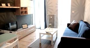 トリノにあるyHome | Barletta Home Apartmentのリビングルーム(青いソファ、テレビ付)