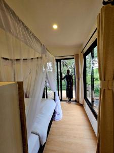 a woman standing in a room looking out the window at MaraRiver TreeHouse in Musiara Campsite