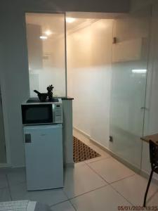 a kitchen with a microwave on top of a refrigerator at Studio 215 Campinas SP in Campinas
