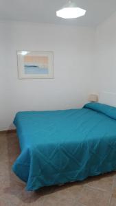 a bed with a blue comforter in a bedroom at Riserva Verde in Castel Porziano +20 photos
