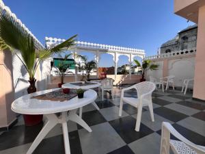a patio with a table and chairs on a roof at Riga House in Udaipur