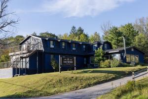 ein großes blaues Haus auf einem Hügel neben einer Straße in der Unterkunft Eastwind in Windham