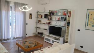 a living room with a couch and a tv at Riserva Verde in Castel Porziano