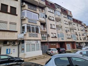 a tall building with cars parked in front of it at Velvet Nest in Kumanovo