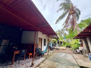 a house with a table and chairs and a palm tree at Juban Guest House in Pooc