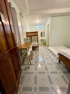 a room with two beds and a desk and a table at Juban Guest House in Pooc +6 photos