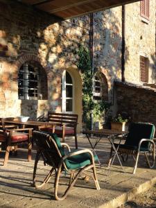 a group of chairs and tables in front of a building at Tuscan Farmhouses at Castello del Calcione Estate in Lucignano