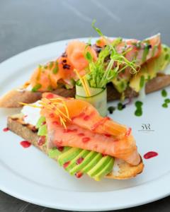 a plate of food with fish and vegetables on toast at Santantonioresort in Riposto