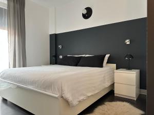 a bedroom with a large bed with a black headboard at Civico6 in Tirano