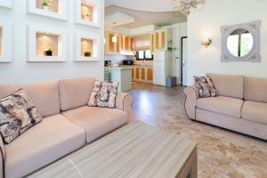 a living room with two couches and a kitchen at Sandra Villa Nea Skioni several steps from the sea in Nea Skioni