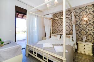 a bedroom with a white canopy bed with white pillows at Sandra Villa Nea Skioni several steps from the sea in Nea Skioni