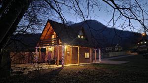 a house lit up at night with christmas lights at Green District - Riverside Luxury Lodge in Banja Luka