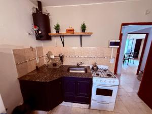 a kitchen with a sink and a stove top oven at Tucuman 890 in Villa María +4 photos