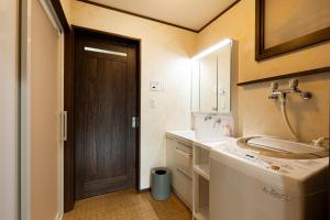a bathroom with a sink and a wooden door at Arai アライ in Takayama +103 photos