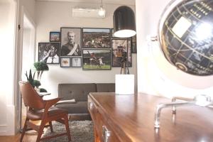 een woonkamer met een bureau en een stoel en foto's aan de muur bij Baixa Charming Apt. | Cascão 18 in Lissabon