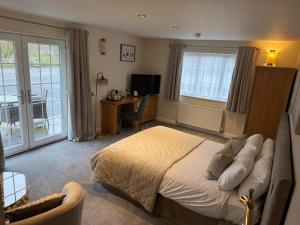 a bedroom with a bed and a desk and window at Charnock Farm in Leyland