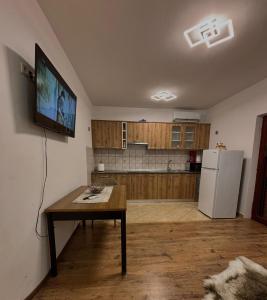 a kitchen with a table and a television on a wall at Tina in Privlaka