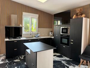 a kitchen with black cabinets and a teddy bear on the counter at Boston - Loft with Jacuzzi in Sanary-sur-Mer