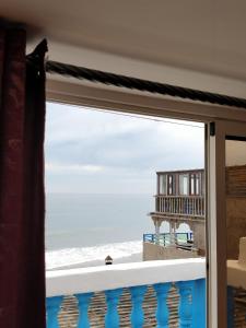 a view of the beach from a window at Taghazout Beachside Haven Ocean View Apartment in Taghazout