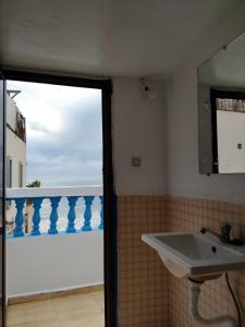 a bathroom with a sink and a view of the ocean at Taghazout Beachside Haven Ocean View Apartment in Taghazout