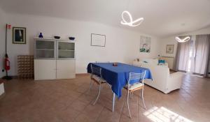 a living room with a blue table and chairs at Riserva Verde in Castel Porziano