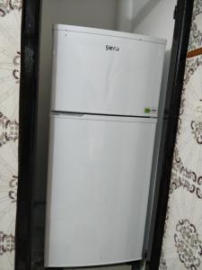 a white refrigerator sitting next to a wall at Taghazout Beachside Haven Ocean View Apartment in Taghazout
