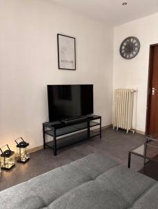 a living room with a flat screen tv and a couch at Stadthaus 34 - Check-in 24h in Kevelaer