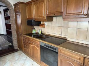 a kitchen with wooden cabinets and a stove top oven at Stadthaus 34 - Check-in 24h in Kevelaer