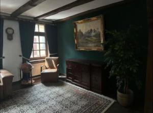 a living room with a couch and a painting on the wall at Stadthaus 34 - Check-in 24h in Kevelaer