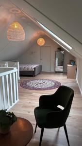a living room with a couch and a chair at Erve t Hoolterhof in Holten