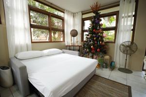 ein Schlafzimmer mit einem weißen Bett und einem Weihnachtsbaum in der Unterkunft CASA RELOJ in Alfonso