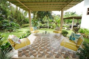 eine Terrasse mit gelben Stühlen und einem Glastisch in der Unterkunft CASA RELOJ in Alfonso