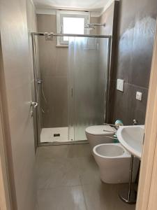 a bathroom with a shower and a toilet and a sink at Acquaviva Suite in San Vincenzo +6 photos