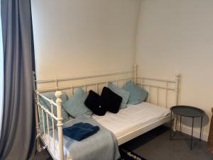 a bed with black and blue pillows on it at Rose villa in Bristol