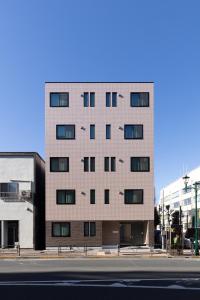a tall brick building with windows on a city street at Hotel Kototoi East in Tokyo